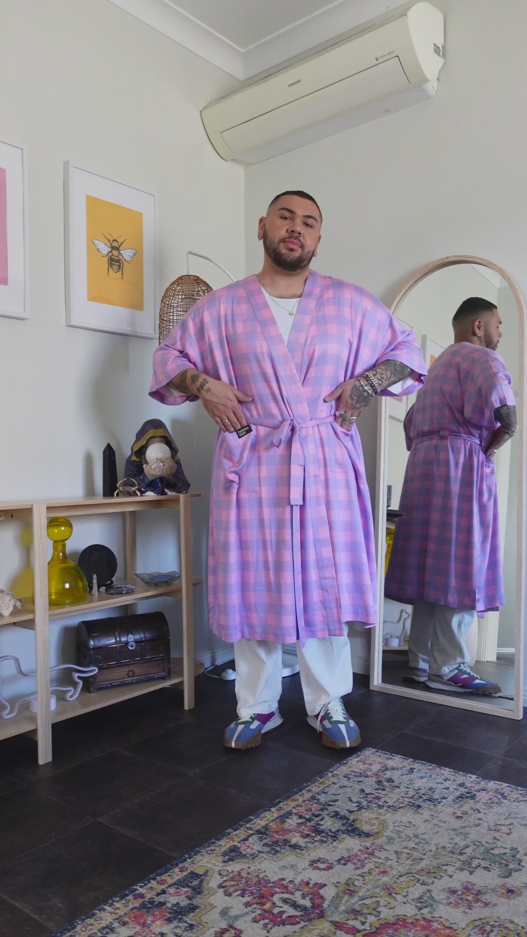 man twirls around wearing pink and purple pastel gingham printed robe in smooth fabric with adjustable tie belt and large pockets