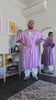 man twirls around wearing pink and purple pastel gingham printed robe in smooth fabric with adjustable tie belt and large pockets